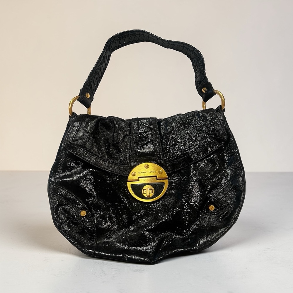 Elliott Lucca black leather shoulder bag with oversized brass turn-lock closure.